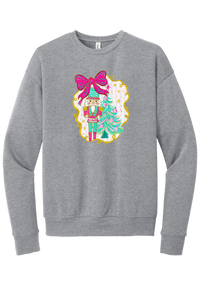 Nutcracker Bow crewneck sweatshirt in Athletic Heather, featuring a teal and pink nutcracker beside a tinsel tree under a big hot pink bow
