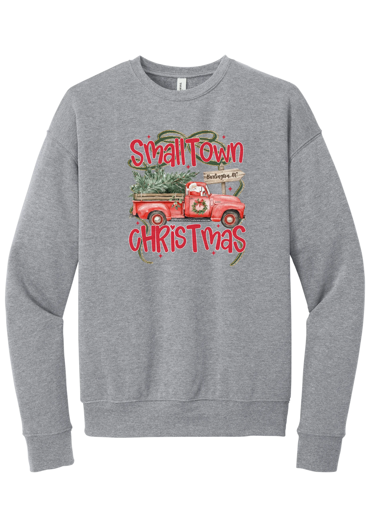 Personalized Small Town Christmas crewneck sweatshirt in Athletic Heather, featuring Santa in a vintage red pickup truck hauling a Christmas tree past a personalized town road sign, with red Small Town Christmas lettering