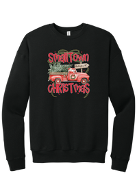 Personalized Small Town Christmas crewneck sweatshirt in Black, featuring Santa in a vintage red pickup truck hauling a Christmas tree past a personalized town road sign, with red Small Town Christmas lettering