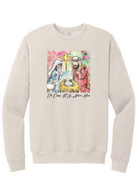 Adore Him Painted Nativity crewneck sweatshirt in Heather Dust, featuring a watercolor nativity of Mary, Joseph, and baby Jesus under a star with Oh Come Let Us Adore Him script