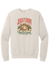 Jesus Is Born Hallelujah crewneck sweatshirt in Heather Dust, featuring a vintage nativity scene under a golden star with Jesus Is Born lettering and Hallelujah script