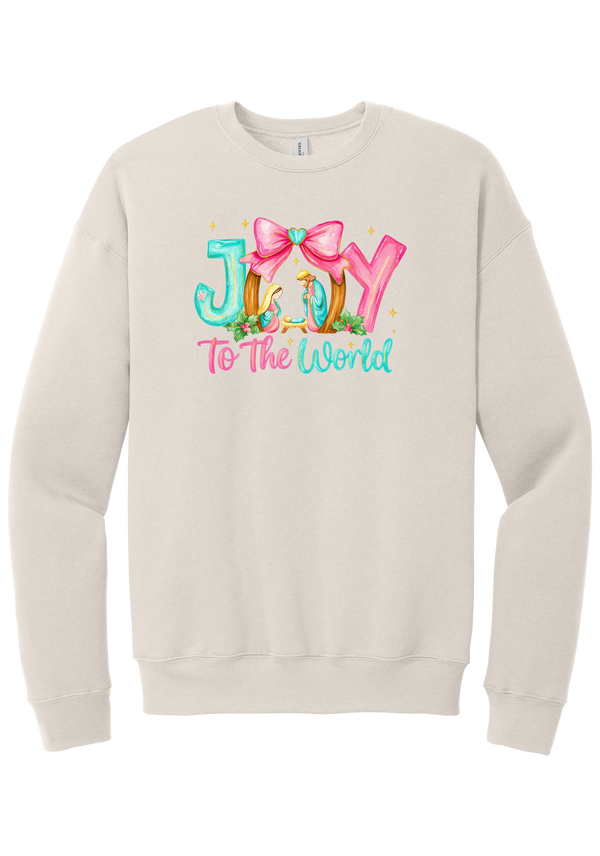 Joy to the World Nativity crewneck sweatshirt in Heather Dust, featuring painted JOY letters framing a nativity scene with a pink bow and To The World script