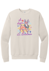 Oh Deer Retro crewneck sweatshirt in Heather Dust, featuring a retro spotted fawn with a holly wreath, pastel stars, and Oh Deer It's Christmas script