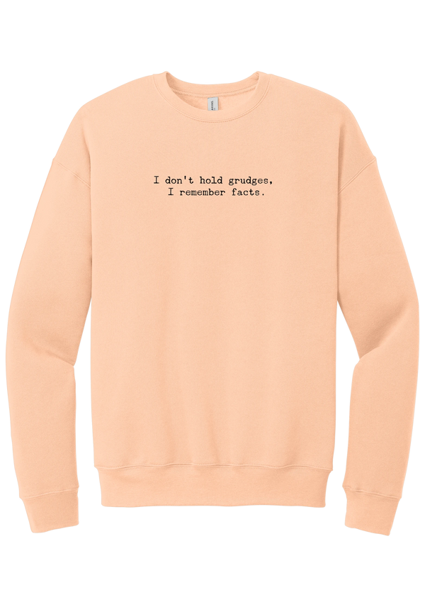 I Don't Hold Grudges crewneck sweatshirt in Peach, featuring I don't hold grudges, I remember facts in distressed black typewriter letters