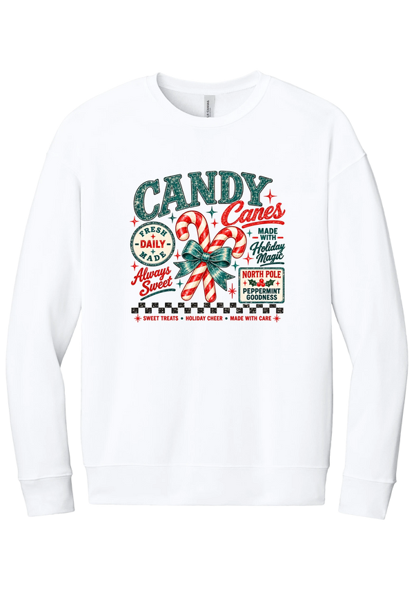 Fresh Candy Canes crewneck sweatshirt in White, featuring vintage candy shop lettering with two striped candy canes tied in a green bow, a North Pole Peppermint Goodness sign, and a checkerboard stripe