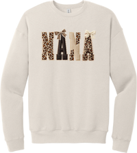 Grandma Leopard Applique crewneck sweatshirt in Heather Dust, featuring NANA spelled out in leopard, cream, and chocolate patches with a scalloped stitched applique look and two bows