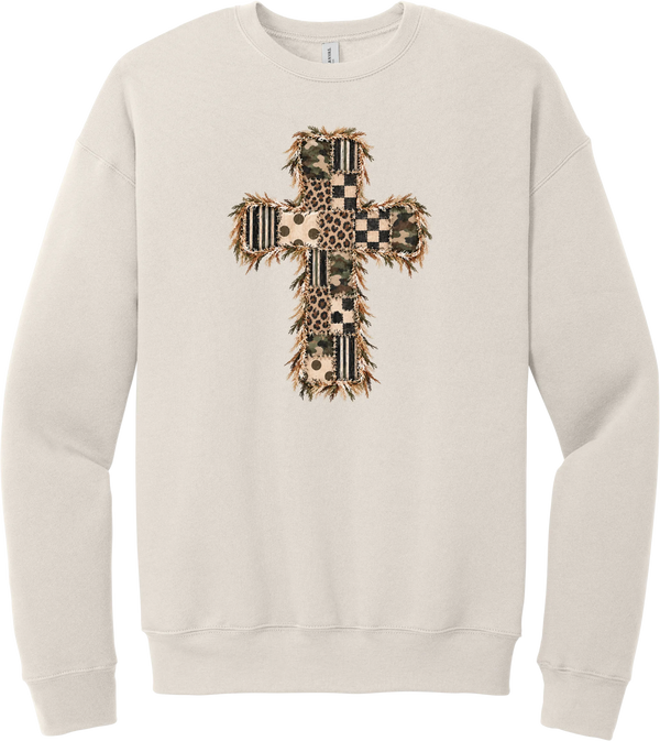 Quilted Patchwork Cross crewneck sweatshirt in Heather Dust, featuring a patchwork cross in camo, leopard, checkerboard, polka dot, and stripes with a fringed edge