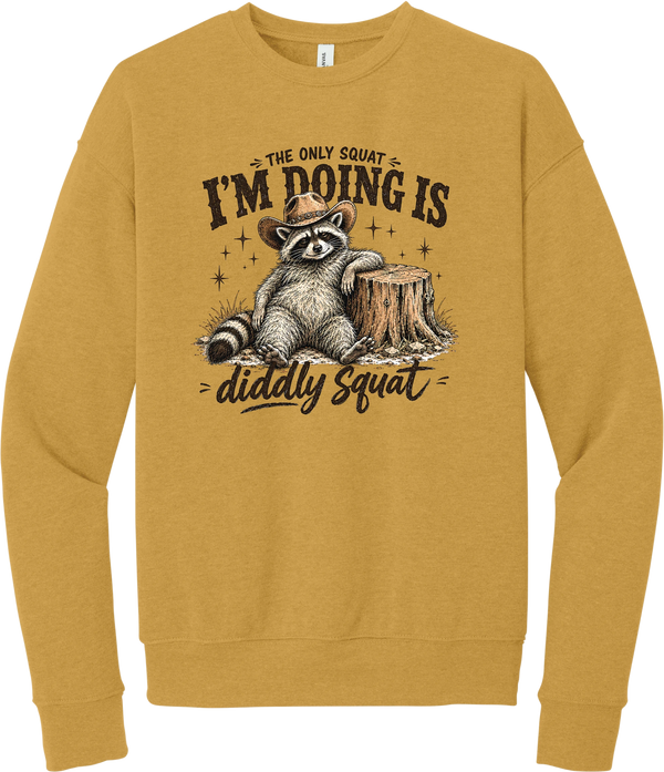 Diddly Squat crewneck sweatshirt in Heather Mustard, featuring a cowboy raccoon lounging against a tree stump with The only squat I'm doing is diddly squat