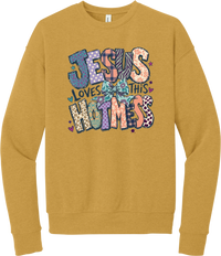 Jesus Loves This Hot Mess crewneck sweatshirt in Heather Mustard, featuring patchwork Jesus Loves This Hot Mess lettering in leopard, plaid, polka dot, and zebra prints with a bow and hearts