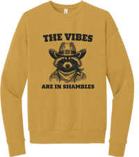 The Vibes Are in Shambles crewneck sweatshirt in Heather Mustard, featuring a cowboy raccoon in a bandana with The vibes are in shambles