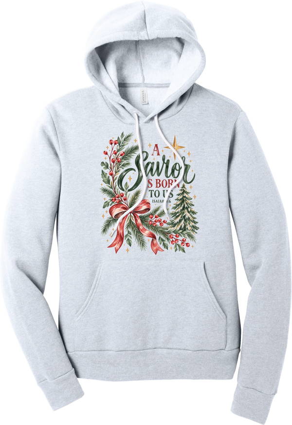 A Savior Is Born To Us hoodie in Ash, featuring watercolor evergreen and holly with a red ribbon bow, the words A Savior is born to us, and Isaiah 9:6
