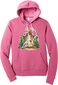 Painterly Nativity hoodie in Heather Charity Pink, featuring a painterly nativity scene with Mary, Joseph, and baby Jesus in a wooden stable between teal Christmas trees and a pink bow