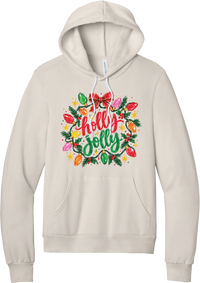 Holly Jolly Christmas Lights hoodie in Heather Dust, featuring hand-lettered holly jolly script framed by vintage Christmas bulb lights, pine, holly berries, and a red bow
