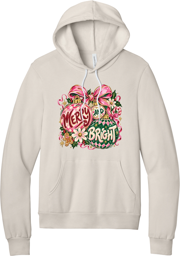 Merry and Bright Ornaments hoodie in Heather Dust, featuring hand-painted pink and green ornaments reading Merry and Bright with a pink bow, holly, daisies, a candy cane, and a gingerbread man