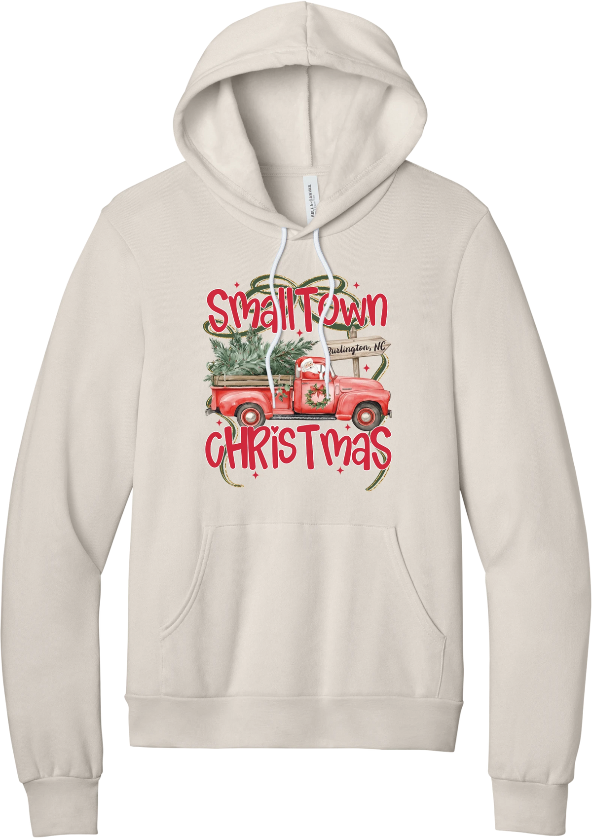 Personalized Small Town Christmas hoodie in Heather Dust, featuring Santa in a vintage red pickup truck hauling a Christmas tree past a personalized town road sign, with red Small Town Christmas lettering