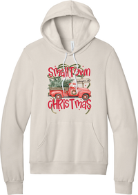 Personalized Small Town Christmas hoodie in Heather Dust, featuring Santa in a vintage red pickup truck hauling a Christmas tree past a personalized town road sign, with red Small Town Christmas lettering
