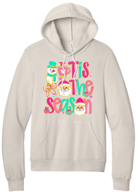 Tis the Season Snowman hoodie in Heather Dust, featuring pink and teal TIS THE SEASON letters with a snowman, a cocoa mug, and Santas