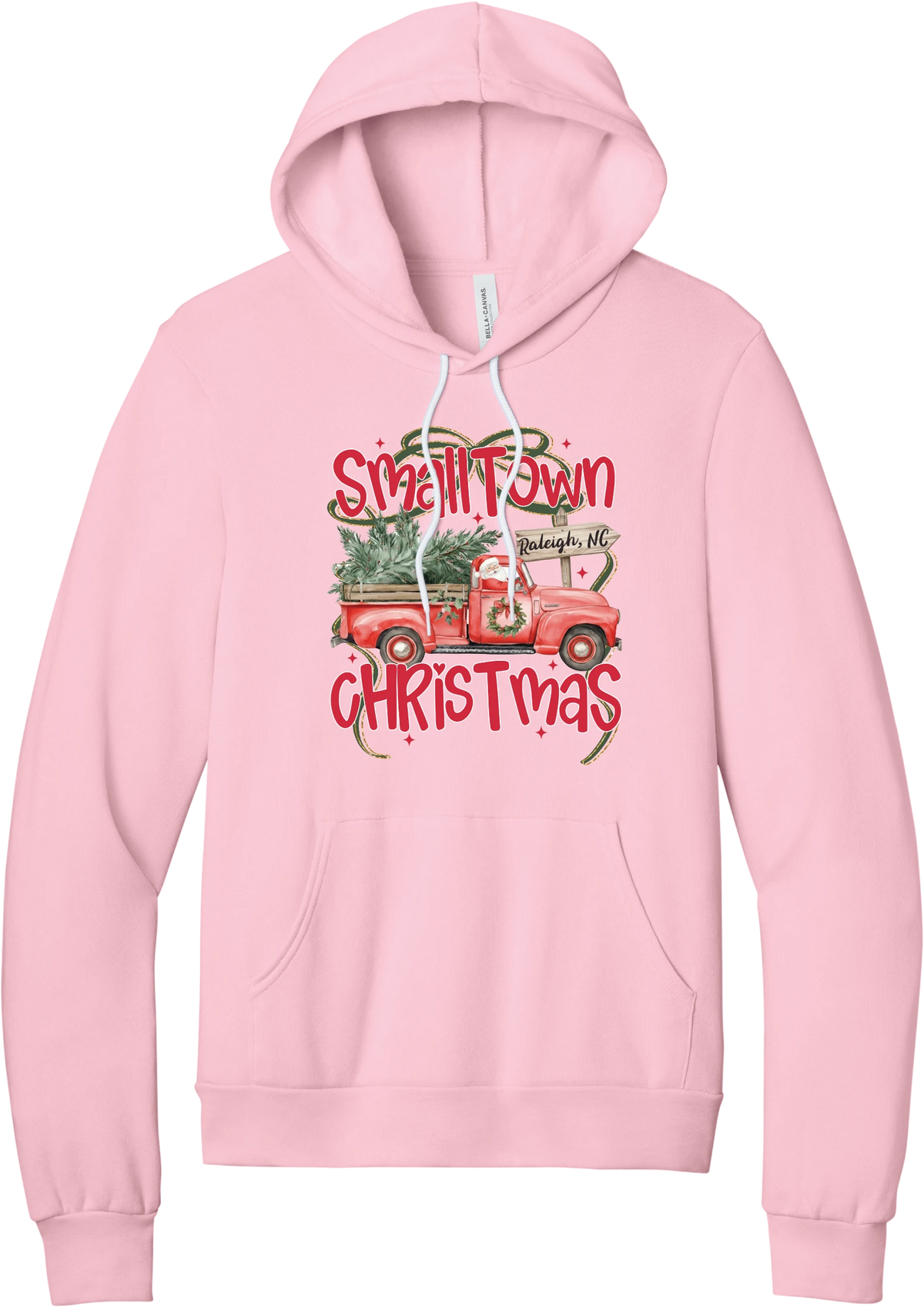 Personalized Small Town Christmas hoodie in Pink, featuring Santa in a vintage red pickup truck hauling a Christmas tree past a personalized town road sign, with red Small Town Christmas lettering