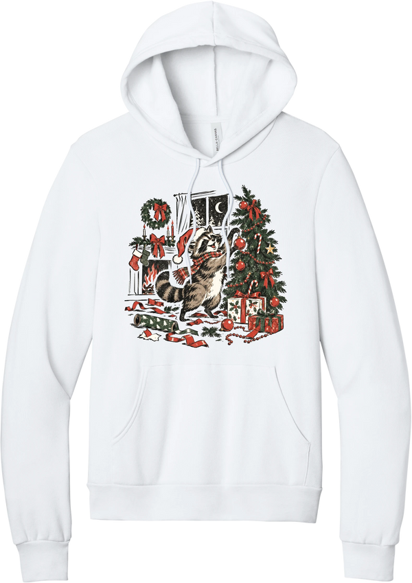 Raccoon Christmas hoodie in White, featuring a vintage-style raccoon in a Santa hat and plaid scarf decorating a Christmas tree by the fireplace with ribbon and gifts scattered around