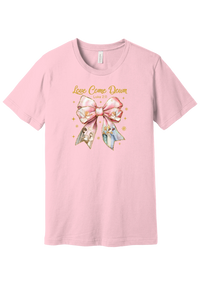 Love Came Down Nativity Bow tee in Pink, featuring a blush satin bow with painted nativity scenes under gold Love Came Down script and Luke 2:11