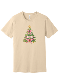 Adore Him Bow Tree tee in Soft Cream, featuring a green Christmas tree dressed in pink bows and a gold star with an Oh Come Let Us Adore Him banner