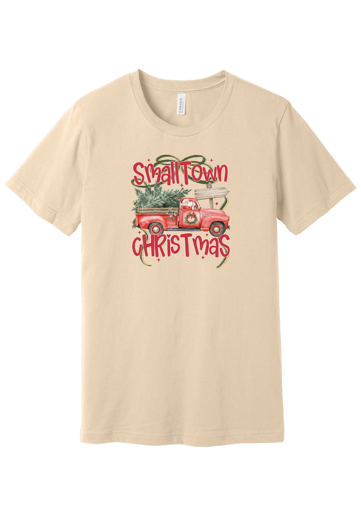 Personalized Small Town Christmas tee in Soft Cream, featuring Santa in a vintage red pickup hauling a Christmas tree past a road sign personalized with your town