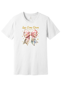 Love Came Down Nativity Bow tee in White, featuring a blush satin bow with painted nativity scenes under gold Love Came Down script and Luke 2:11